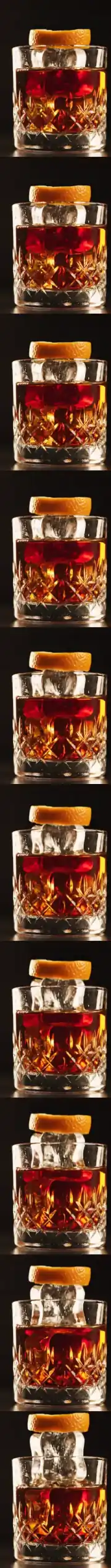 Un Negroni en vaso de cristal tallado: el hielo y la piel de naranja se elevan del vaso a medida que se baja por la pagina