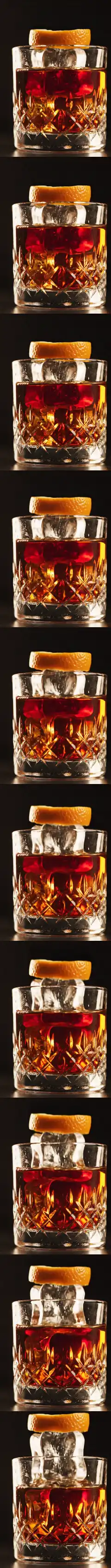 Un Negroni en vaso de cristal tallado: el hielo y la piel de naranja se elevan del vaso a medida que se baja por la pagina